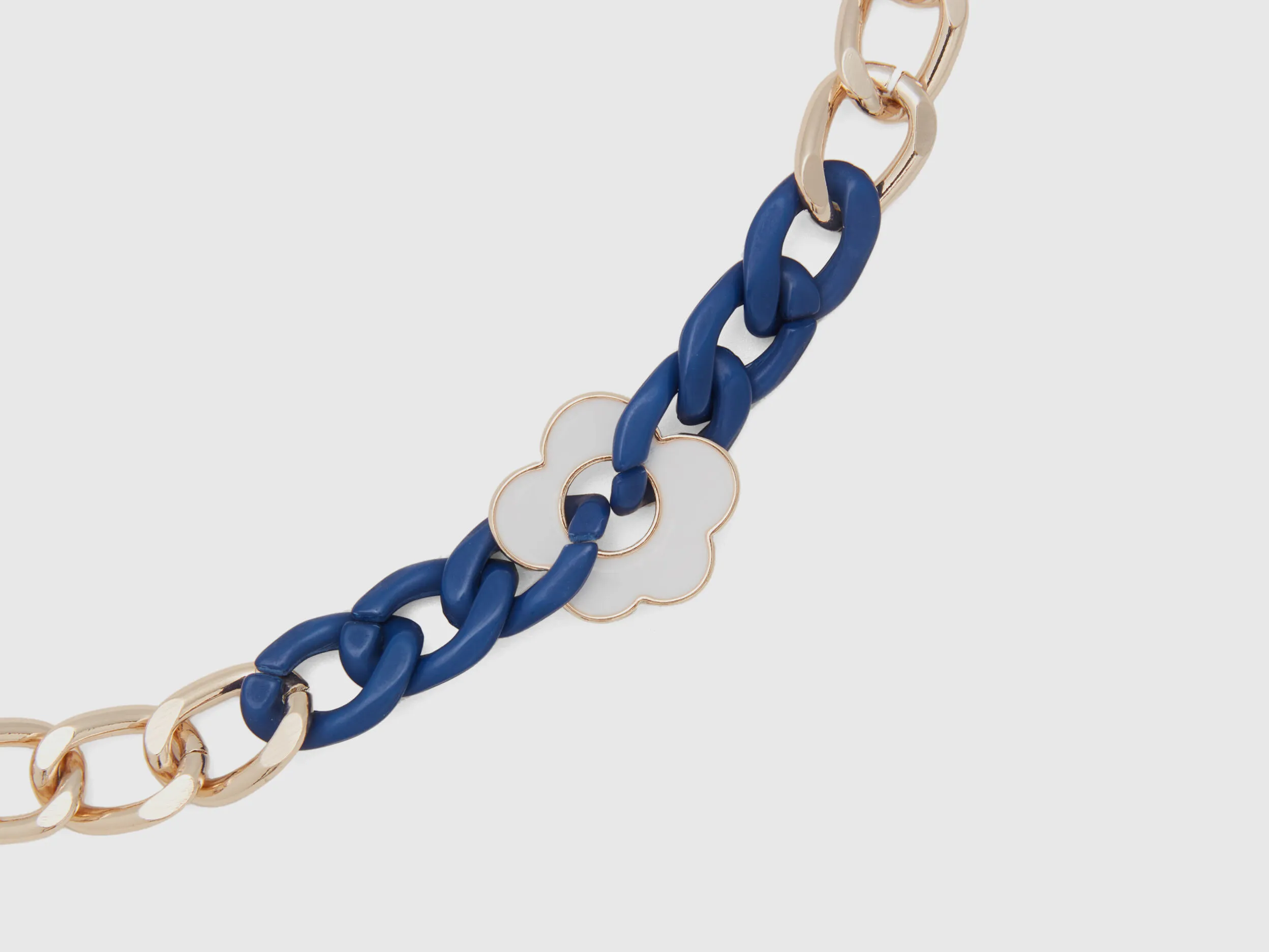 Pulsera dorada y azul con flor blanca