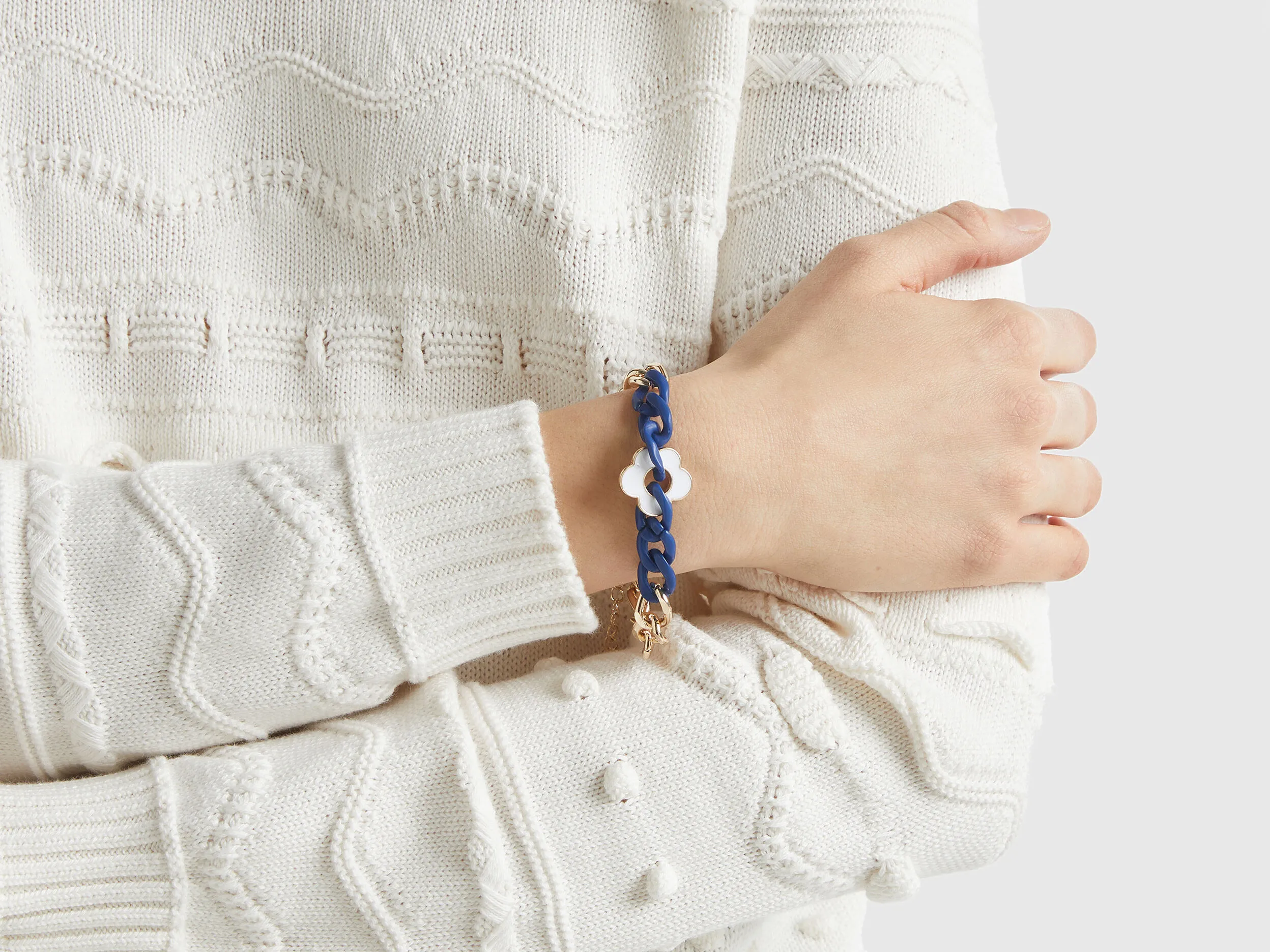 Pulsera dorada y azul con flor blanca